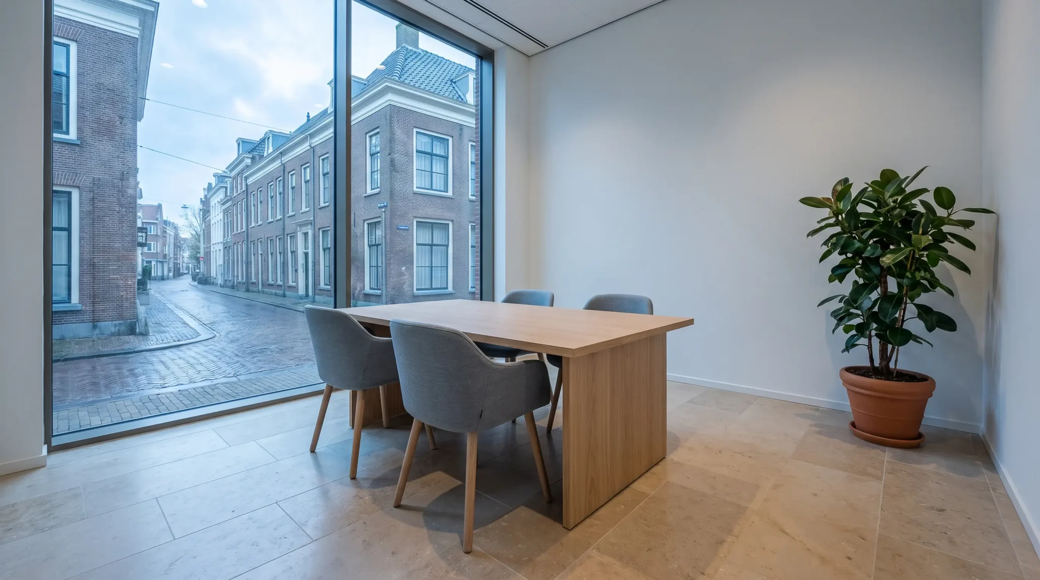 Rustige moderne vergaderruimte met houten tafel en uitzicht op een bakstenen straat